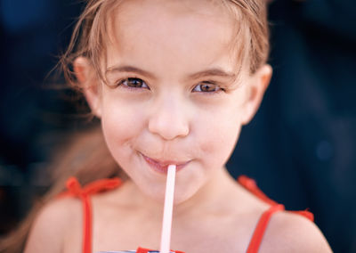 Portrait of smiling girl drinking juice