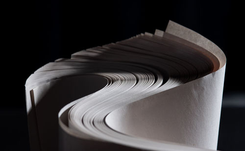 Close-up of spiral book against black background