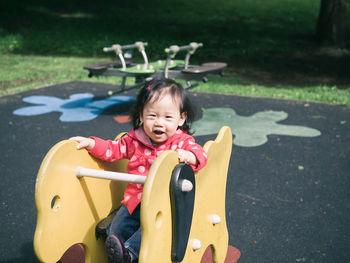 Portrait of happy baby girl playing with outdoor play equipment