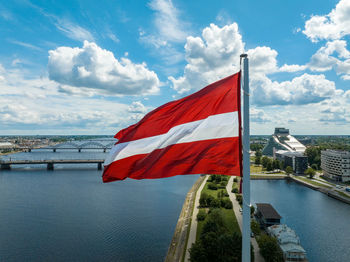 Latvian flag with the dome cathedral and national library in the background