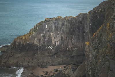 Rock formations on sea shore. rock climbers near sea.