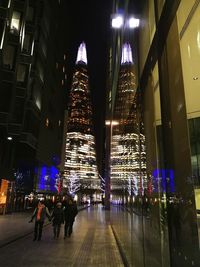 People in illuminated modern building at night