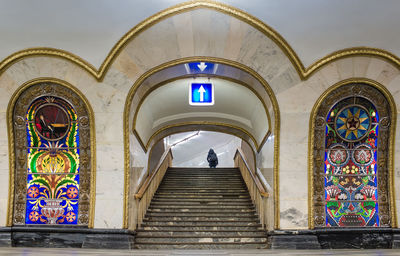 Illuminated arrow symbol over staircase at novoslobodskaya