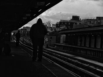 Rear view of woman walking on railway station platform