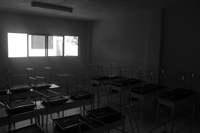 Empty chairs and tables in window