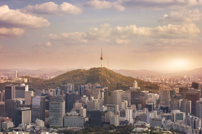 Buildings in city against cloudy sky