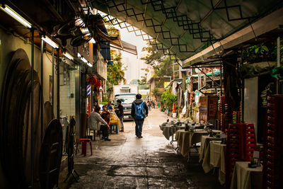 Rear view of people walking on street market in city