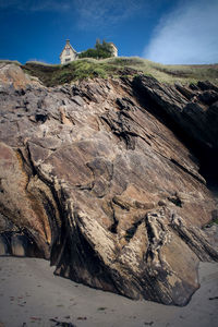 Close-up of house on cliff against sky