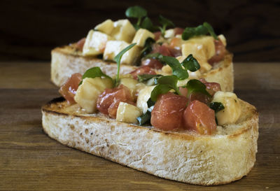 Close-up of bruschetta served with tomatoes on cutting board