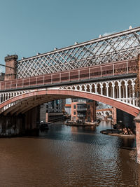 Arch metal bridge over canal basin in castlefield manchester in teal and orange 