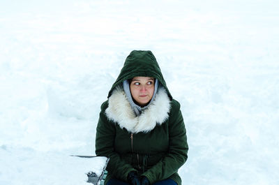 Young woman sitting on seat during winter