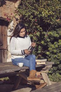 Woman pours a cup of tea from the thermos, outdoors,