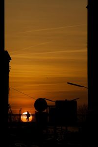 Silhouette buildings against sky during sunset