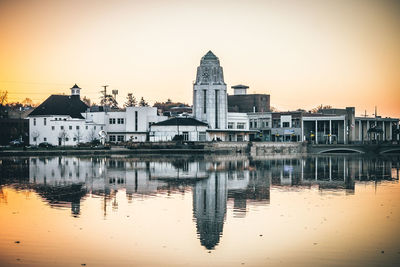 Reflection of buildings in city at sunset