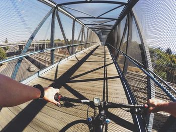 Cropped image of man riding bicycle on bridge