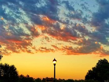 Low angle view of street light against orange sky