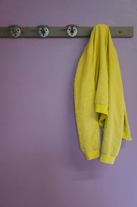 Close-up of yellow jacket hanging on rack at home
