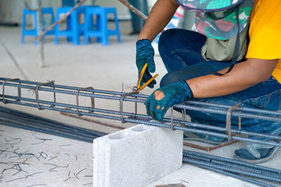 Closeup hands of worker doing the steelwork for reinforcement steel structure at the site.