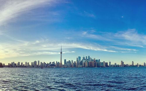 Sea by buildings against sky in city