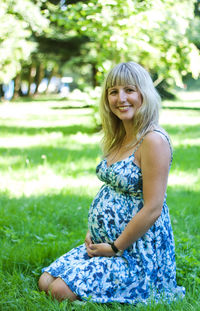 Portrait of beautiful pregnant woman in park