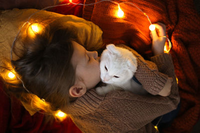Sleeping baby girl hugging a white cat with ears, a cozy childhood and home environment