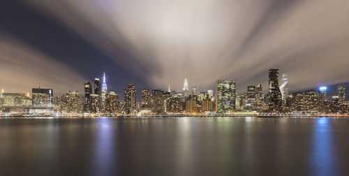 Illuminated buildings in city against sky at night