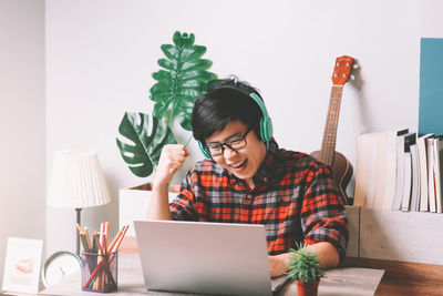 Young woman using phone while sitting on table