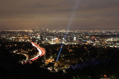 Aerial view of illuminated cityscape against sky at night