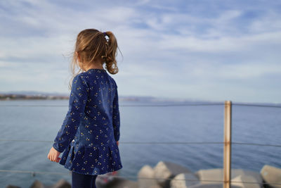 Rear view of woman looking at sea against sky