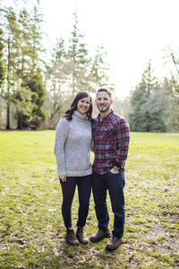 Confident, attractive couple standing outdoors.