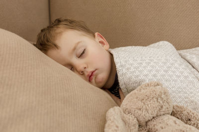 Little, cute caucasian boy sleeping on couch at home. child taking day nap. kid resting, relaxing 