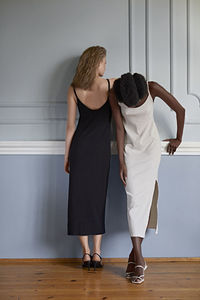 Rear view of friends standing against wall