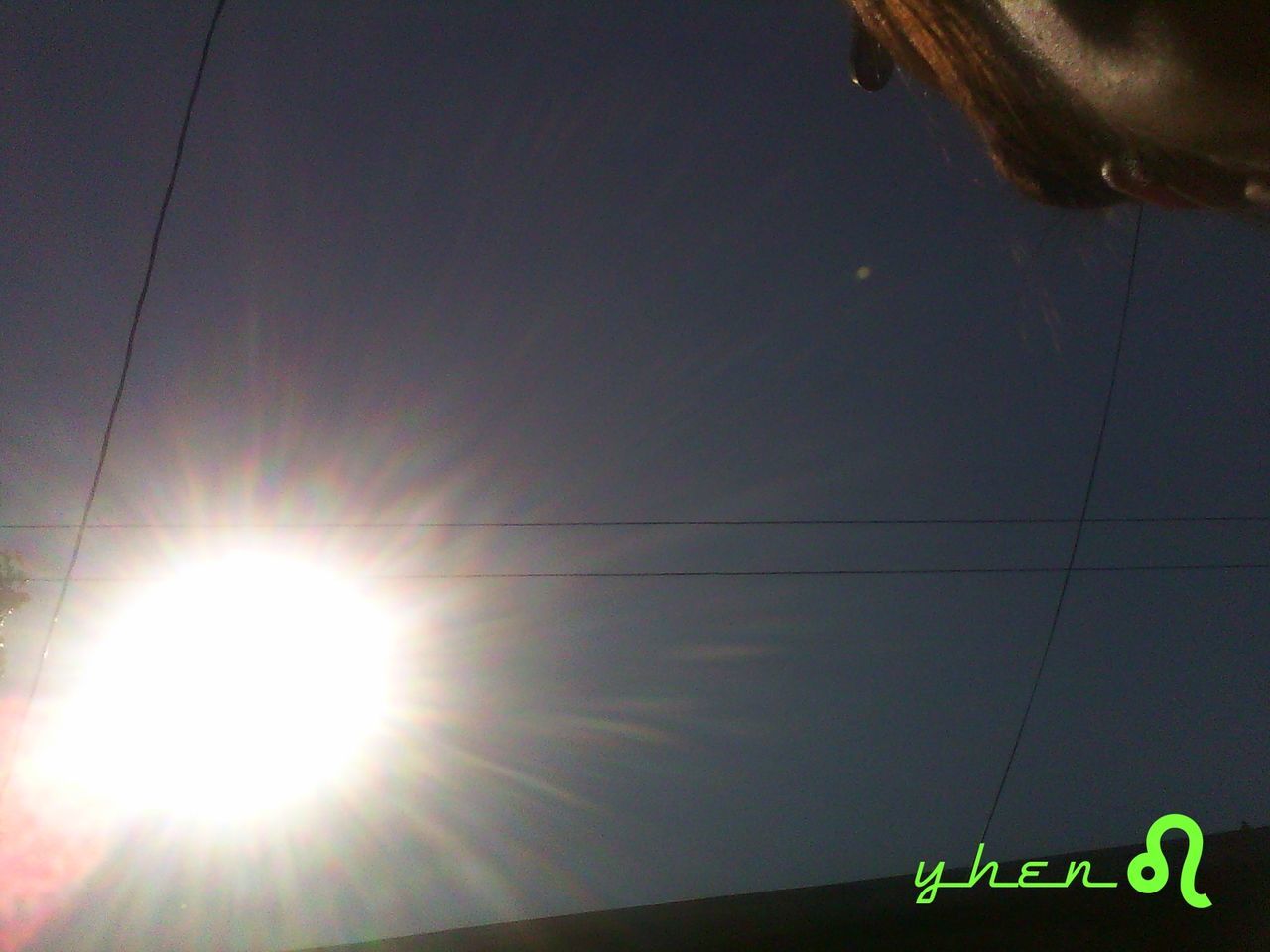 low angle view, text, communication, western script, transportation, sun, guidance, sunlight, sky, information sign, road sign, mode of transport, outdoors, nature, no people, sign, day, clear sky, sunbeam, lens flare