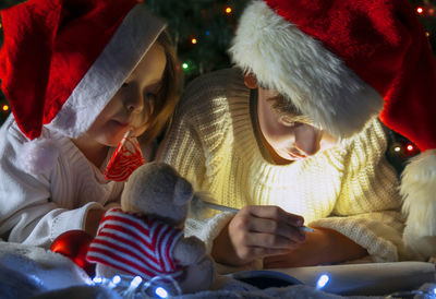 Rear view of mother and daughter on christmas tree