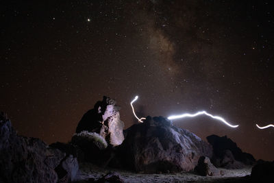 Low angle view of rock formation against sky at night