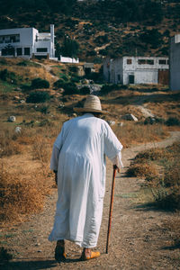 Rear view of men walking on street by building