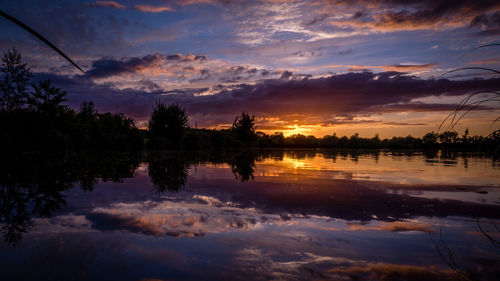 Scenic view of lake against sky at sunset