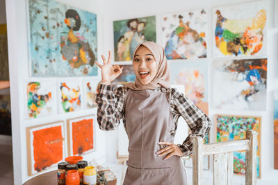 Portrait of smiling young woman standing on table