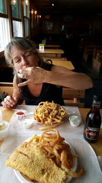 Woman eating food in restaurant