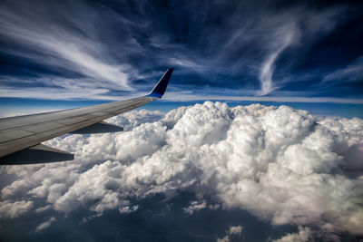 Airplane flying over cloudscape against sky
