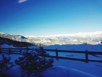 Scenic view of snowcapped mountains against clear blue sky