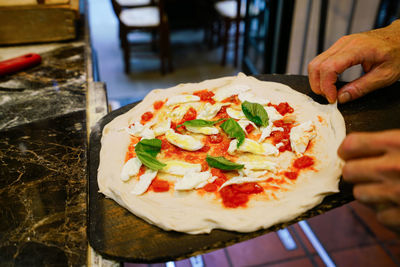 Close-up of hand holding pizza