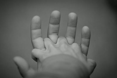 Cropped hands of people against gray background