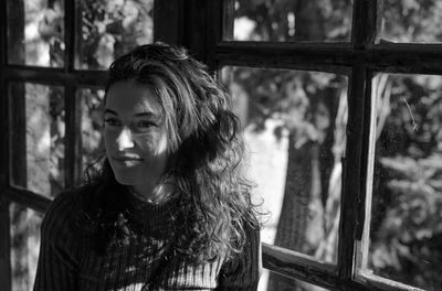 Young woman looking whith behind a window