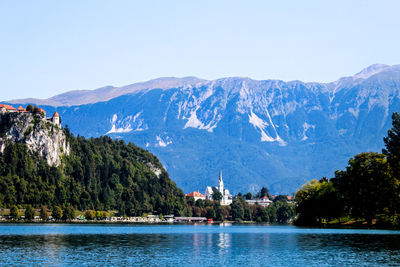 Scenic view of sea and mountains against clear sky