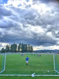 Soccer field against cloudy sky