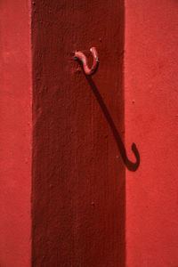 Close-up of red hook mounted on wall