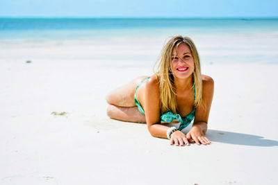 Beautiful  smiling woman lying on the beach