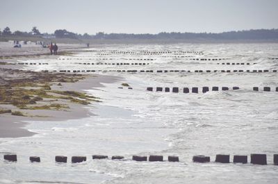 People at beach against sky