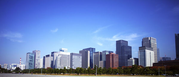 Low angle view of skyscrapers against blue sky